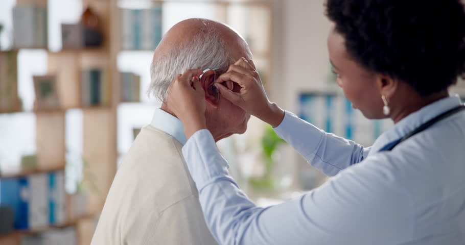 Senior, man and consultation with doctor for hearing aid, medical prescription and restore sound. Female audiologist, elderly deaf patient and device or implant for tinnitus and geriatric support.