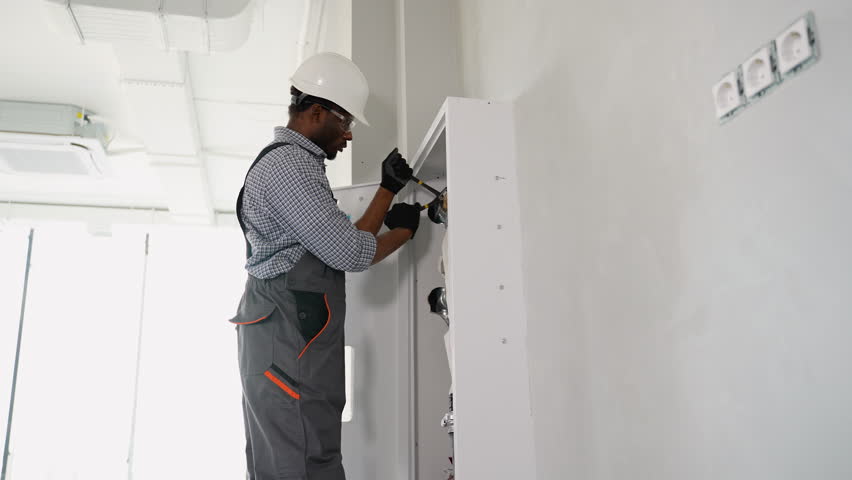 African american plumber installing fire hydrant in office. Fire protection systems maintenance for safety