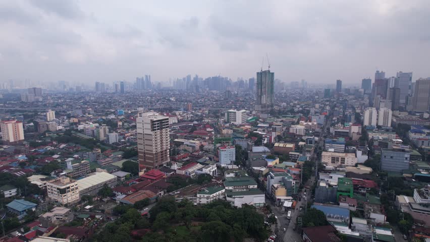 Manila philippines on a grey cloudy day showing the epic skyline and smaller suburbs below split up by skyscrapers, roads, and tres