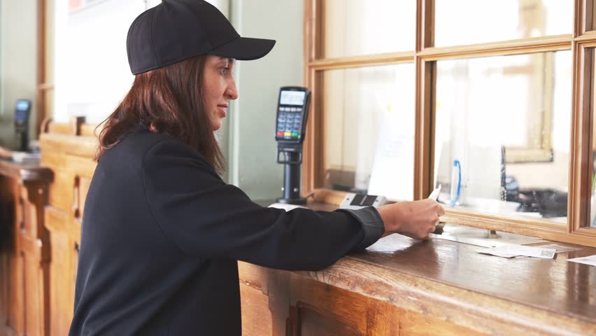 Woman in black cap Buying Ticket In cash register On The Train Or Subway Station.