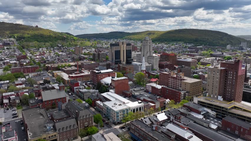 Downtown Reading, Pennsylvania. Urban cityscape with prominent courthouse and surrounding buildings. Hills in the background. Aerial during bright spring day.