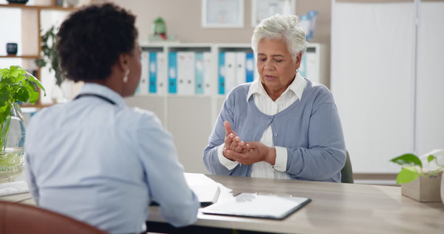 Arthritis, doctor and senior woman with hand pain, diagnosis or joint problem with inflammation. Pensioner, old person or mature lady with caregiver, specialist and talk for medicare or treatment