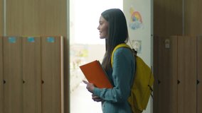 Side view happy smiling Caucasian student girl smile female schoolgirl woman pupil teenager teen walking going in school corridor walk go in university college hall education study holding copybooks - Powered by Shutterstock - Get 15% off with code: PIKWIZARD15