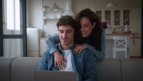 Happy loving Caucasian woman female girl wife girlfriend walk to sofa hugging embracing man busy computer addict laptop distant freelance working man male guy boyfriend husband couple talking home - Powered by Shutterstock - Get 15% off with code: PIKWIZARD15