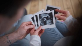 Unrecognizable pregnant couple pregnancy medical insurance health parents at clinic at home man guy male father woman girl female mother holding usd ultrasound examination photo images future baby - Powered by Shutterstock - Get 15% off with code: PIKWIZARD15