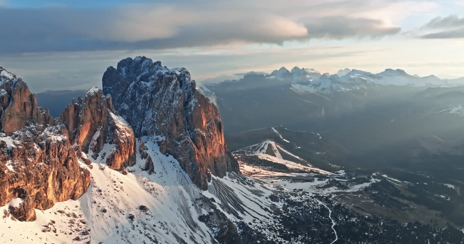 Aerial view of the top of Mount Langkofel in Italy. Sunset over a beautiful snowy mountain range in the Dolomite Alps. Tourism and natural landscapes in travel. High quality 4k footage