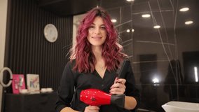 Beautiful woman hairdresser smiling with dryer and brush on dark background. - Powered by Shutterstock - Get 15% off with code: PIKWIZARD15