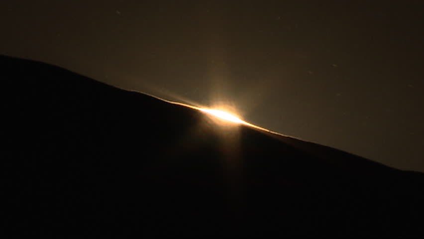 Sunrise over dark sand dunes