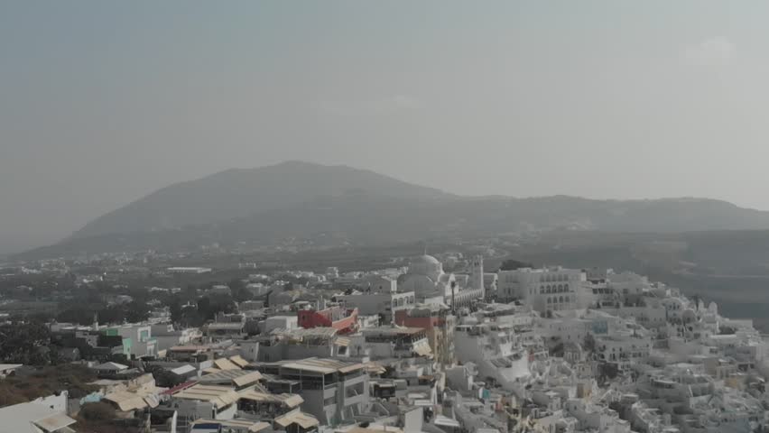 Aerial panorama of white houses, near viewpoint, Santorini Cable Car Overlook in Fira, Santorini Island, Greece. Thira city. Aegean Sea, Mediterranean. Panoramic aerial drone view from above
