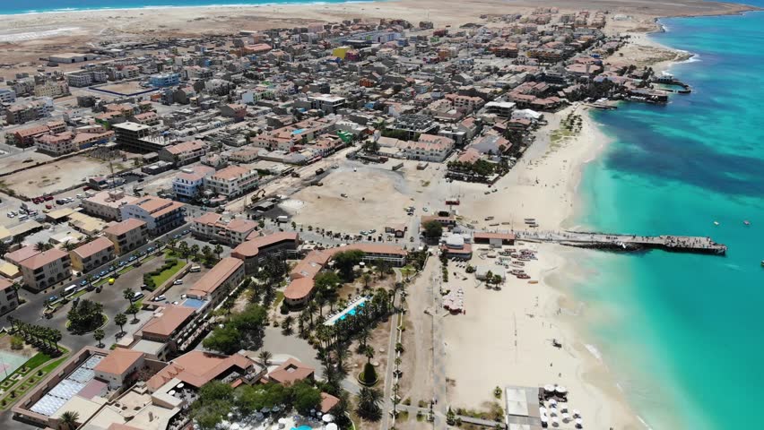 Aerial drone footage of the beach of Cape Verde or Capo Verde showing the famous fishermans pier and the golden sandy beaches on a hot summer day in the summer time