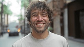 Young man smiling outdoors in an urban street, showcasing an attractive portrait of a hispanic male adult in a city setting - Powered by Shutterstock - Get 15% off with code: PIKWIZARD15