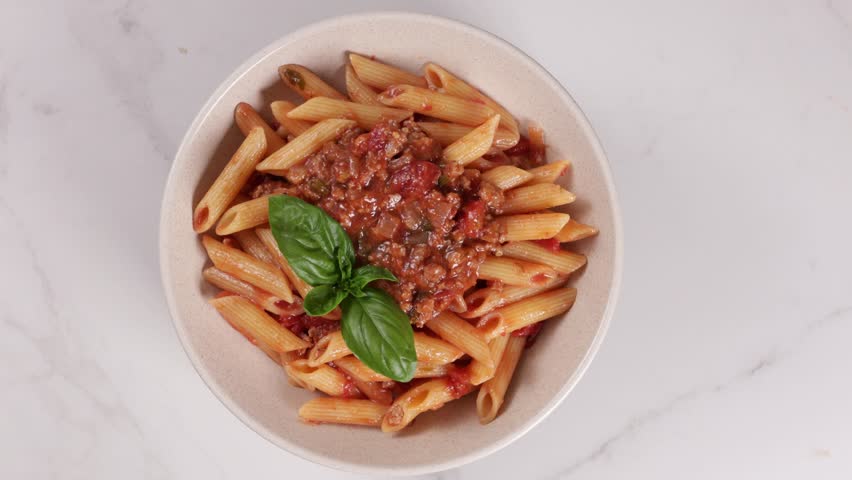 pasta penne bolognese top view in bowl food rotation