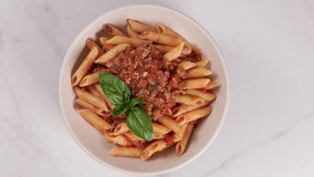 pasta penne bolognese top view in bowl food rotation - Powered by Shutterstock - Get 15% off with code: PIKWIZARD15