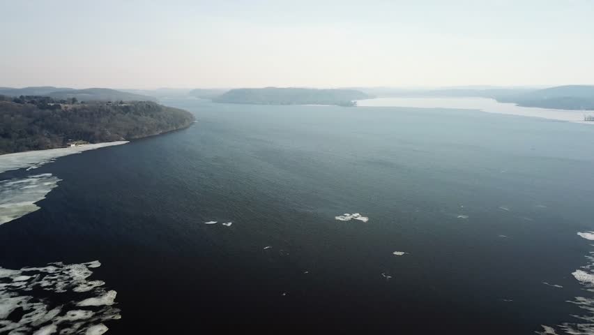 Aerial view of Lake Wisconsin with partially frozen water and surrounding hills, capturing the serene winter landscape.