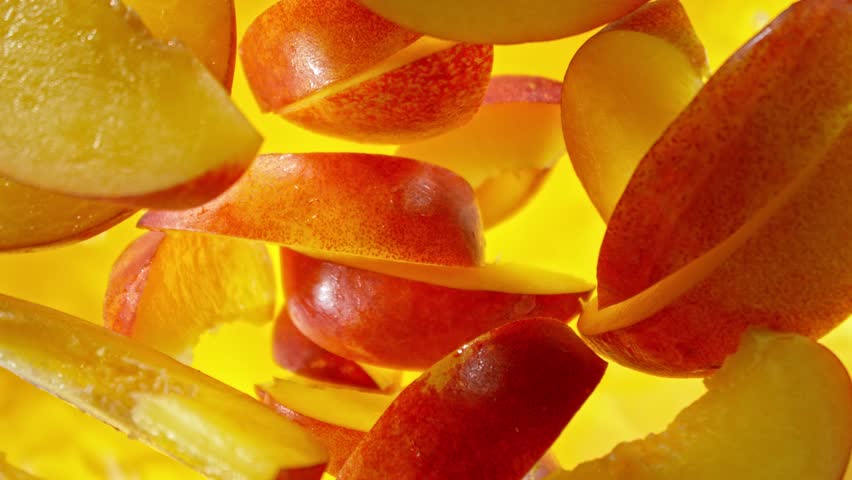 Super Slow Motion of Falling Peaches Slices into Water, Colored Background. Filmed on High Speed Cinema Camera, 1000 fps. Camera Tracking the Target.
