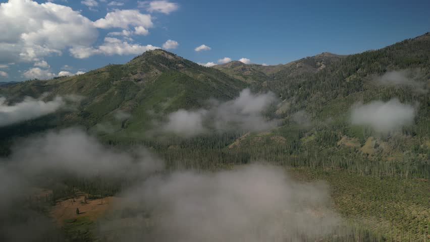 Aerial into low cloud in Sawtooth Mountains near Stanley Idaho in early morning in summer