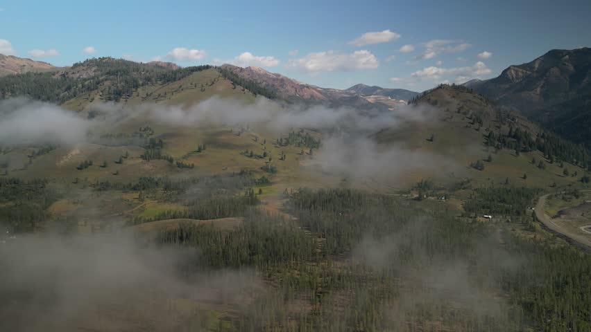 Aerial of low clouds near Sawtooth Mountains in Stanley Idaho on early summer morning