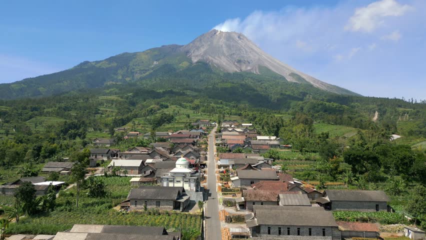 Aerial view of the active Merapi volcano and picturesque village on its slope in Indonesia