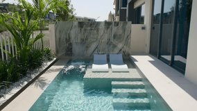 A small private swimming pool in the backyard of a luxury villa in Dubai on a sunny day - Powered by Shutterstock - Get 15% off with code: PIKWIZARD15