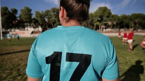 A female rugby player in a blue jersey with number 17 holding a rugby ball, preparing for the game. Female Rugby Player Holding Ball Before Game - Powered by Shutterstock - Get 15% off with code: PIKWIZARD15