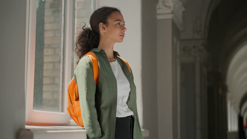 Portrait happy smiling confident Hispanic woman student girl Latina female lady in school university college academy hall corridor stand posing crossed hands looking at camera education exam studying