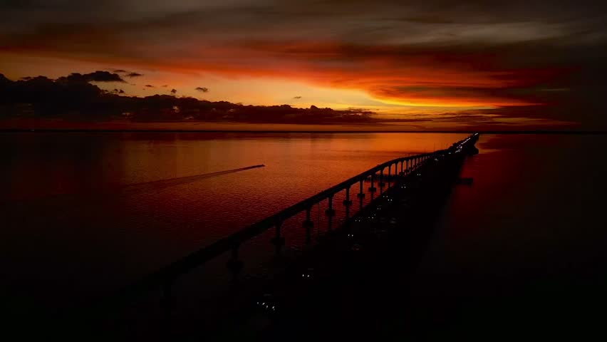 An aerial view of a mesmerizing bright flaming sunset over the bridge