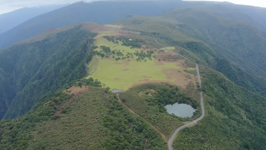 An aerial video of the lake surrounded by rocky mountains covered with trees