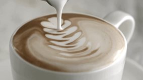 Latte art being made. Closeup video of coffee latte art making at cafe. Milk being poured into a white mug with coffee, creating a beautiful latte art. - Powered by Shutterstock - Get 15% off with code: PIKWIZARD15