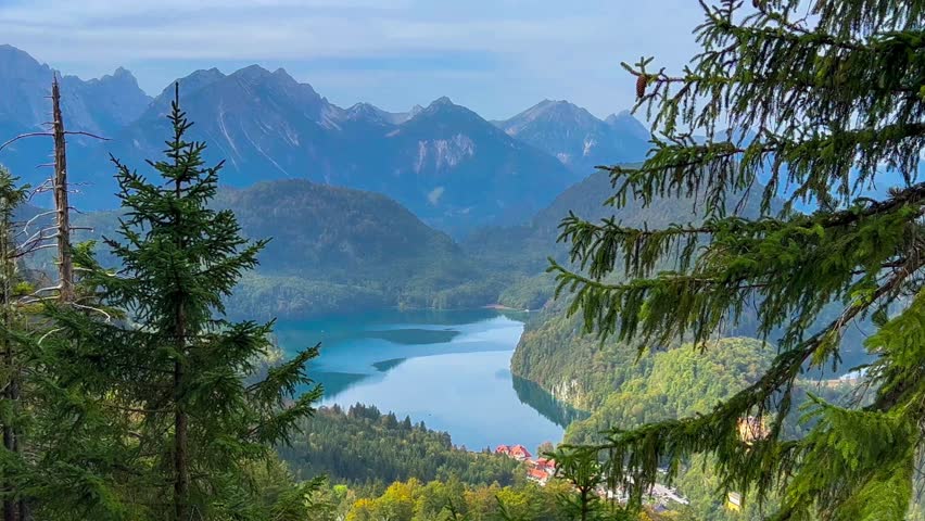 Landscape lake in mountains among pine forest in vicinity of the castle Neuschwanstein castle on Alps background, Bavaria, Germany, Europe. Autumn landscape lake in mountains 