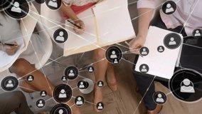 Animation of network of connections with icons over diverse business people discussing work. Business, technology and digital interface concept digitally generated video. - Powered by Shutterstock - Get 15% off with code: PIKWIZARD15