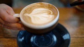 Woman drinking Coffee With Latte Art while working at coffee shop. beautiful woman enjoying cappuccino in a cafe. Delicious fresh cappuccino at cafe. - Powered by Shutterstock - Get 15% off with code: PIKWIZARD15