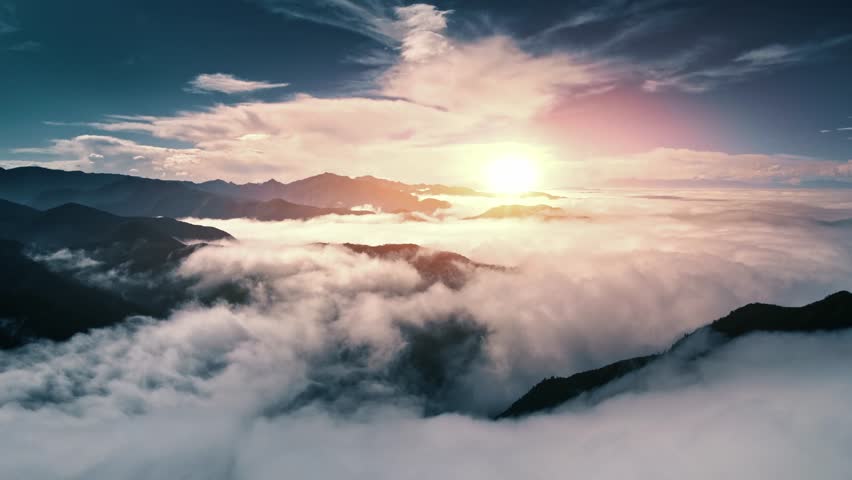 A landscape scene of cloudscape vague on silhouette mountains with colorful sunset sky