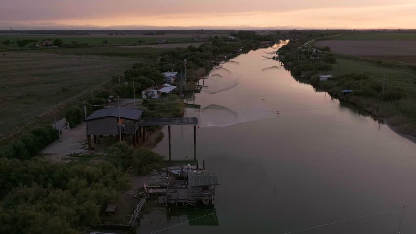 A beautiful aerial view over a serene river reflecting the darkening sky in the wilderness at sunset