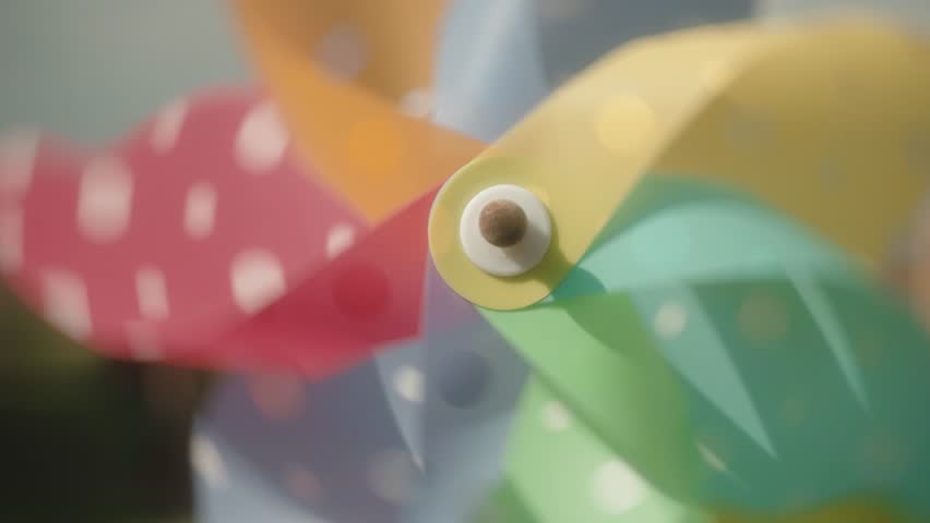 A closeup of a colorful spinning Pinwheel on the blurry background