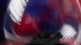 A closeup of the black sand pouring in the hourglass on the blue and red background - Powered by Shutterstock - Get 15% off with code: PIKWIZARD15