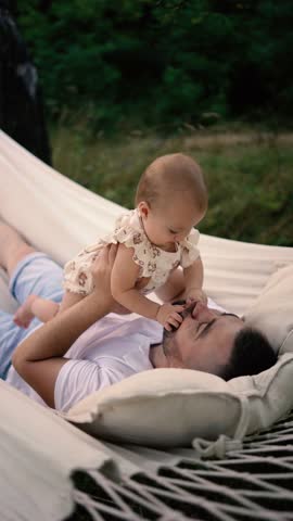 dad playing with his baby daughter in  hammock