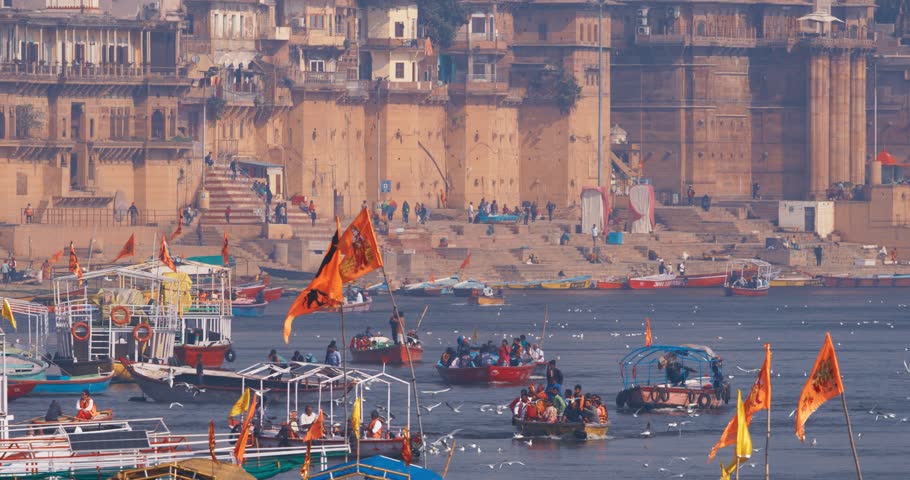 Varanasi, Uttar Pradesh, India. Many Boats with Tourists pilgrims floating on the Ganga riverbank. Tourists boats floating on the Ganges River. Cityscape of Varanasi is visible - embankment in the