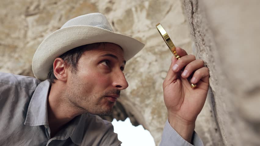 Archaeologist studies inscriptions on an ancient wall