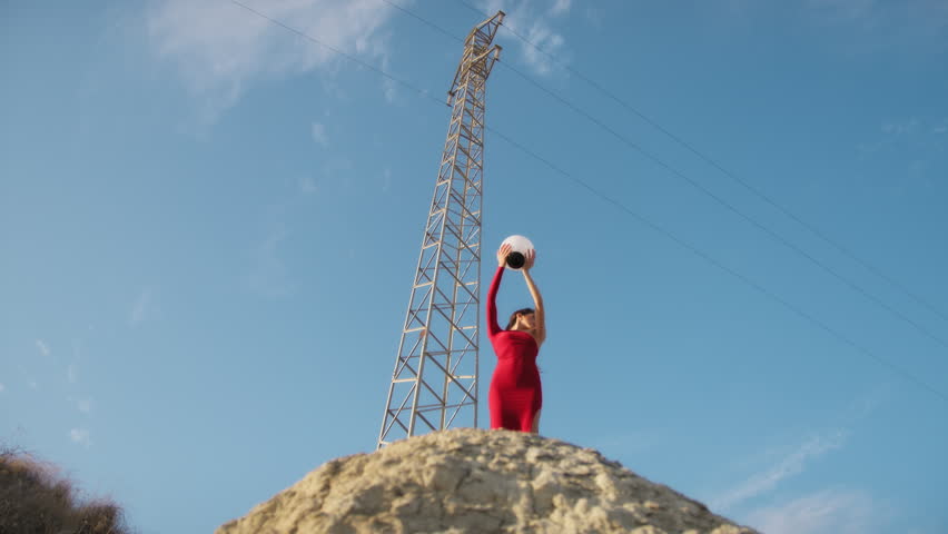 Girl With Red Dress Holds A Philosophical Ball In Silhouette