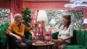 Happy senior people playing chess in a cozy home setting, thinking about strategy moves during board game leisure activity. Enjoyment of strategic intellectual hobby, mastermind pastime. Camera B. - Powered by Shutterstock - Get 15% off with code: PIKWIZARD15