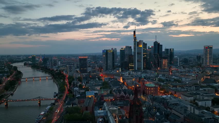 Dolly Flight through Frankfurt am Main, Germany. Skyline. New Skyscrapers. Urban Canyon in Sunset or Sunrise Light. Aerial Pedestal in Establishing Night Drone Shot. Glowing street lights