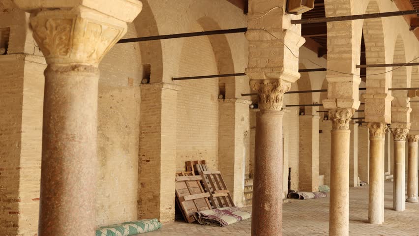 Corridor gallery around inner courtyard of Great Mosque of Kairouan in Tunisia with traditional Islamic arches and columns decorated with Corinthian capitals 