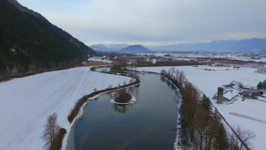 An aerial scenery of the bare trees on the snowy bank of the Sumas River in British Columbia, Canada