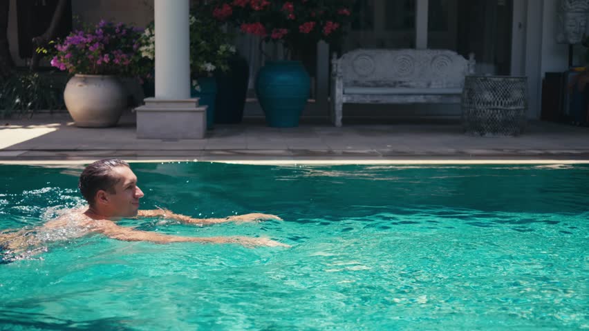 Man swims private pool luxury villa. Male embraces active lifestyle swimming private pool afforded villa