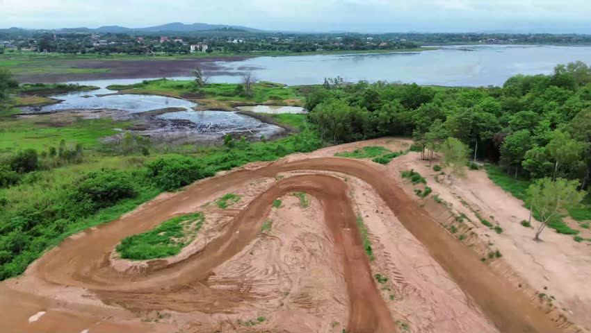 Aerial view of a Scenic Dirt Bike Trail Near the River at Sunset