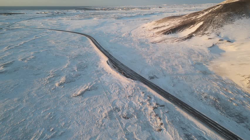 A drone view of a snow covered road in Iceland