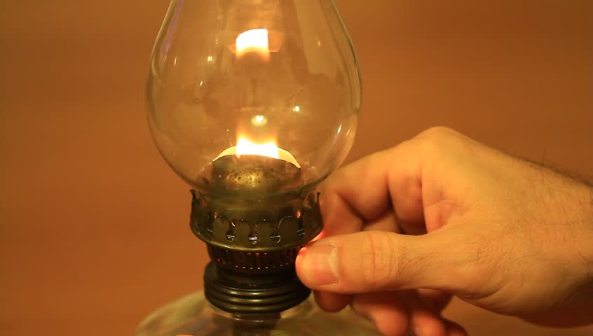 Man preparing an old fashioned lantern. Storm lantern burning at night
