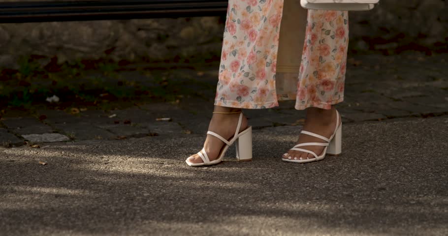 A woman with white high heels and a dress