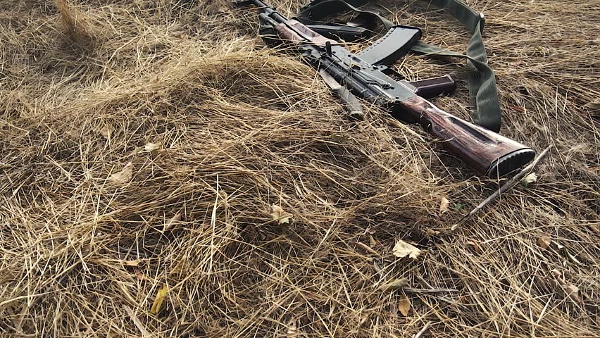 A wounded soldier reaches for his weapon.