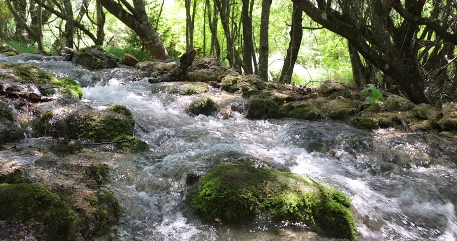 Beautiful mountain waterfall with fast flowing water and rocks, streams and cascades with moss and grass. Natural seasonal travel outdoor beauty in nature Sopotnica in Serbia, slow motion